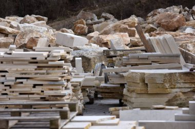 Taş ürünlerinin işlenmesi için atölye çalışması. Açık havada dekoratif doğal taş deposu. Üretim için kireçtaşı kesimleri