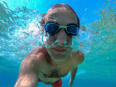 Eğleniyor ve denizde Yüzme sırasında sualtı selfie alarak komik adam