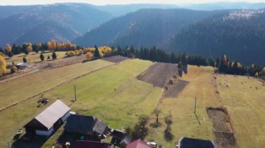 Sonbaharın, yaprak döken ormanların ve dağ köylerinin ve çiftliklerin üzerinde uçuyorlar. Hava 4k dron görüntüsü