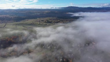 Sabah bulutlarından yükselen tepelerin insansız hava aracı görüntüsü.