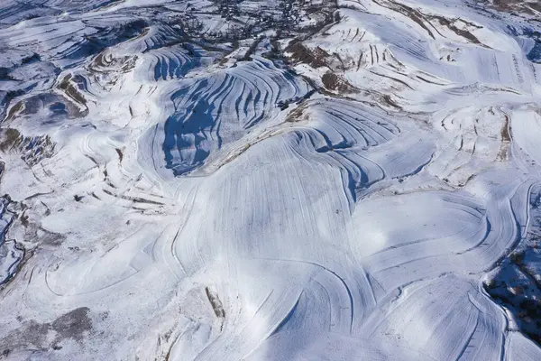 Dağlardaki kırsal terasları kaplayan karlı hava aracı görüntüsü