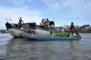 CAI RANG, VİETNAM - 17 Şubat 2013: Mekong deltasındaki ahşap tekneleriyle seyahat eden ve çalışan insanlar sadece tekne ve gemilerde ulaşımın mümkün olduğu yerler
