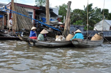 CAI RANG, VİETNAM - 17 Şubat 2013: Mekong deltasındaki ahşap tekneleriyle seyahat eden ve çalışan insanlar sadece tekne ve gemilerde ulaşımın mümkün olduğu yerler