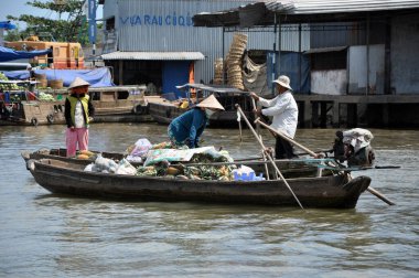 CAI RANG, VİETNAM - 17 Şubat 2013: Mekong deltasındaki ahşap tekneleriyle seyahat eden ve çalışan insanlar sadece tekne ve gemilerde ulaşımın mümkün olduğu yerler