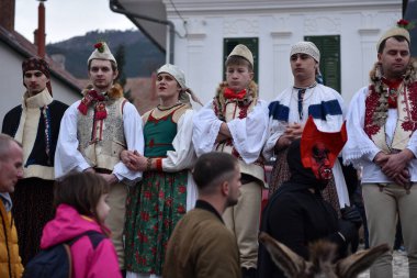 RIMETEA, ROMANIA - 2 Mart 2024: Kimliği belirsiz erkekler kışın sonunda karnavalı kutlayan kadın kıyafetleri giydiler