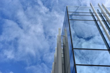 Düşük açılı bir gökdelen, mavi gökyüzüne karşı cam cephe