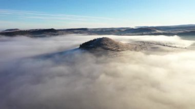 Gizemli sisli kış sabahında tepelerin üzerinden uçuyor. Havadan yavaş çekim görünümü