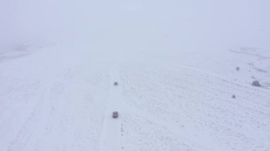 Sisli, sisli kış havasında kış yolunda giden arabaların hava görüntüsü.