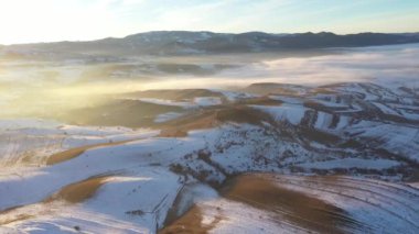  İnsansız hava aracı ile, soğuk kırsal tepelerin üzerindeki günbatımı manzarası.