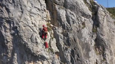  İpe asılı kurtarma operasyonları yapan bir dağcının hava görüntüsü.