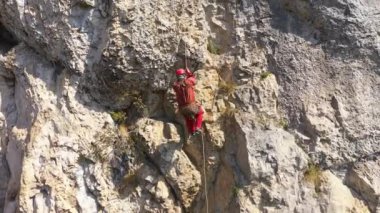  İpe asılı kurtarma operasyonları yapan bir dağcının hava görüntüsü.