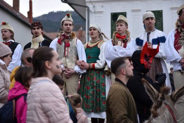 RIMETEA, ROMANIA - 2 Mart 2024: Kimliği belirsiz erkekler kışın sonunda karnavalı kutlayan kadın kıyafetleri giydiler