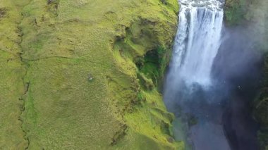 Baharda Skogafoss şelalesi. Canlı yeşil çimenler. Yavaş çekim hava görüntüsü