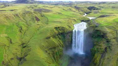 İzlanda, Skogafoss şelalesinin yavaş çekim görüntüsü. Canlı yeşil İzlanda manzarası 