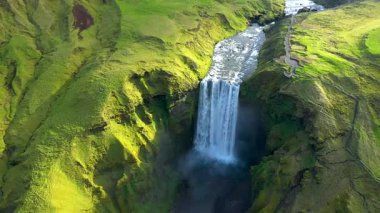  İzlanda, Skogafoss şelalesinin yavaş çekim görüntüsü. Canlı yeşil İzlanda manzarası 