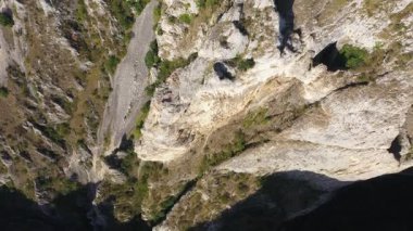 Derin bir vadide, kanyonda, kaya tırmanışı havasında dikey kireçtaşı duvarların içinden uçuyor. 