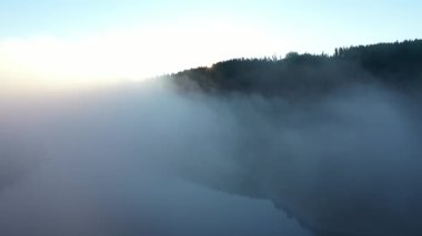 Yavaş çekim bulutların hava görüntüsü, sisli ve sisli bir sabah ve güneş ışınları arka planı