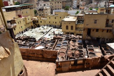 FEZ, MOROCCO - 31 Mayıs 2025: Chouara Tannery 'de deri döken işçiler, farklı renklerde boya ve beyaz sıvılarla dolu sayısız taş fıçı