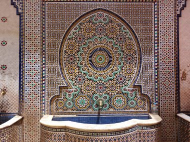 El yapımı mozaik fayanslar ve zellige ile işlenmiş karmaşık geometrik desenler içeren Fas halk mozaik çeşmeleri
