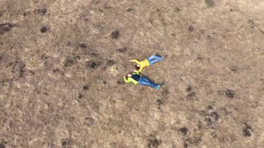 Eşcinsel kız arkadaşlar çayırın ortasında uzanıyorlar, hava ağır çekim manzarası. 