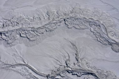 Gri, soyut çamur kalıpları ve asit madenindeki çatlakların havadan görüntüsü insansız hava aracıyla boşaltılıyor.