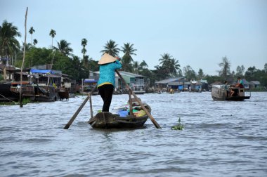 CAI RANG, VİETNAM - 17 Şubat 2013: Mekong deltasındaki ahşap tekneleriyle seyahat eden ve çalışan insanlar sadece tekne ve gemilerde ulaşımın mümkün olduğu yerler
