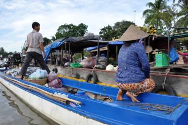CAI RANG, VİETNAM - 17 Şubat 2013: Mekong deltasındaki ahşap tekneleriyle seyahat eden ve çalışan insanlar sadece tekne ve gemilerde ulaşımın mümkün olduğu yerler