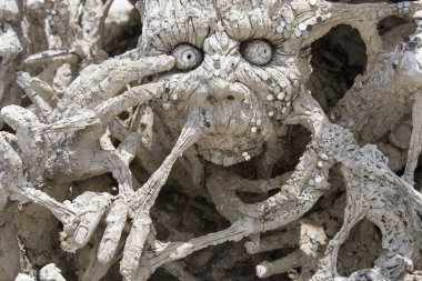 Sculpture of spectral face at Wat Rong Khun, Chiang Rai, Thailand.