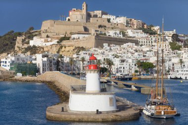 İbiza, İspanya - 9 Haziran 2025: İbiza Limanı girişindeki Botafoc Deniz Feneri, İbiza, Balear Adaları, İspanya, eski şehir, Rönesans duvarları ve arka planda Dalt Vila.