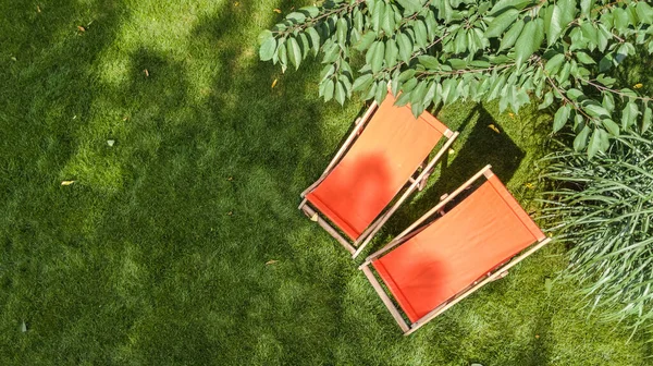 정원에 위에서 일광욕을 즐기는 의자가 의나무들 그리고 위에서 수있는 스톡 사진