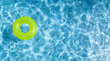 Yüzme havuzunda renkli yüzüklü çörek oyuncağı yukarıdan havuz manzarası, aile tatilleri tatil beldesi arka planı.