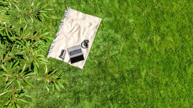 Laptop bilgisayar ve kulaklıklar park yeşil çim üzerinde, çevrimiçi açık havada çalışma, ofis konsepti dışında çalışma, yukarıdan hava üst görünümü