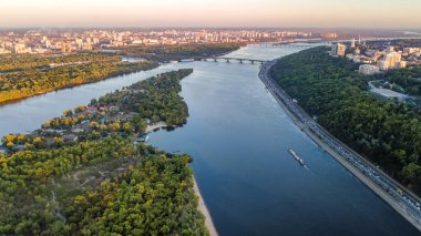 Kyiv şehrinin ufuk çizgisi ve yukarıdan Dnipro nehri hava aracı görüntüsü, Kiev köprüleri ve baharda Dinyeper nehir adaları, Ukrayna