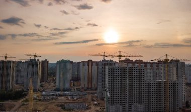 Yukarıdan, Ukrayna Kiev şehrinin kentsel silüeti gün batımında Vinçler ile yerleşim bölgesinde binaların inşaat sitesinin havadan görünümü