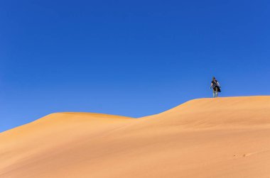Güzel gündoğumu kırmızı kum tepelerinde yürüyen turistler Sossusvlei 'de Afrika macerası Namib Çölü, Namibya, Güney Afrika