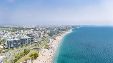 Antalya şehir manzarası ve Konyaalti plajı, kumsalda güneşlenen, denizde yüzen ve dinlenen insanlar, Türkiye 'de Antalya tatil beldesi