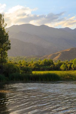 Dağlardaki göl. Güzel doğa, bulutların ve dağların mavi sulardaki yansıması. Kırgızistan