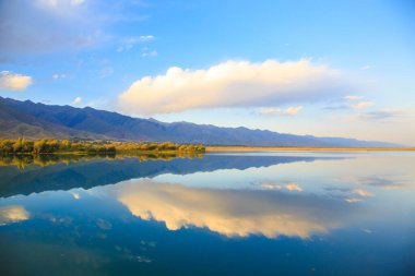 Dağlardaki göl. Güzel doğa, bulutların ve dağların mavi sulardaki yansıması. Kırgızistan
