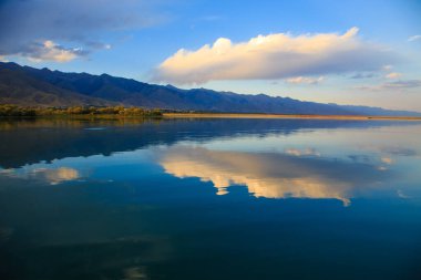 Dağlardaki göl. Güzel doğa, bulutların ve dağların mavi sulardaki yansıması. Kırgızistan