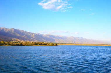 Dağlardaki göl. Güzel doğa, bulutların ve dağların mavi sulardaki yansıması. Kırgızistan