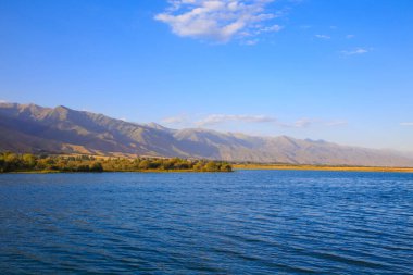 Dağlardaki göl. Güzel doğa, bulutların ve dağların mavi sulardaki yansıması. Kırgızistan