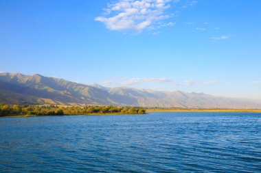 Dağlardaki göl. Güzel doğa, bulutların ve dağların mavi sulardaki yansıması. Kırgızistan