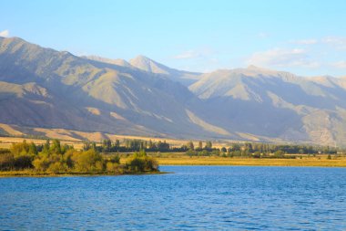 Dağlardaki göl. Güzel doğa, bulutların ve dağların mavi sulardaki yansıması. Kırgızistan
