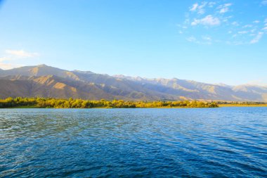 Dağlardaki göl. Güzel doğa, bulutların ve dağların mavi sulardaki yansıması. Kırgızistan
