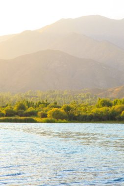 Dağlardaki göl. Güzel doğa, bulutların ve dağların mavi sulardaki yansıması. Kırgızistan