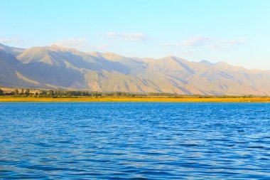 Dağlardaki göl. Güzel doğa, bulutların ve dağların mavi sulardaki yansıması. Kırgızistan