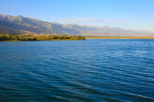 stock image Lake in the mountains. Beautiful nature, reflection of clouds and mountains in blue water. Kyrgyzstan