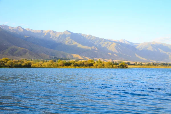 stock image Lake in the mountains. Beautiful nature, reflection of clouds and mountains in blue water. Kyrgyzstan