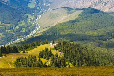 Dağ yaz manzarası. Karlı dağlar ve yeşil çimenler. Zirve Karakolu Kırgızistan.