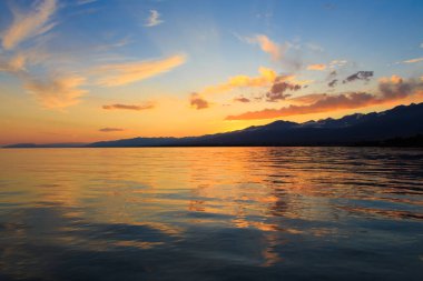 Mavi ve turuncu berrak su dokusu. Okyanusun ve denizin arkaplanı güneşle aydınlanıyor..